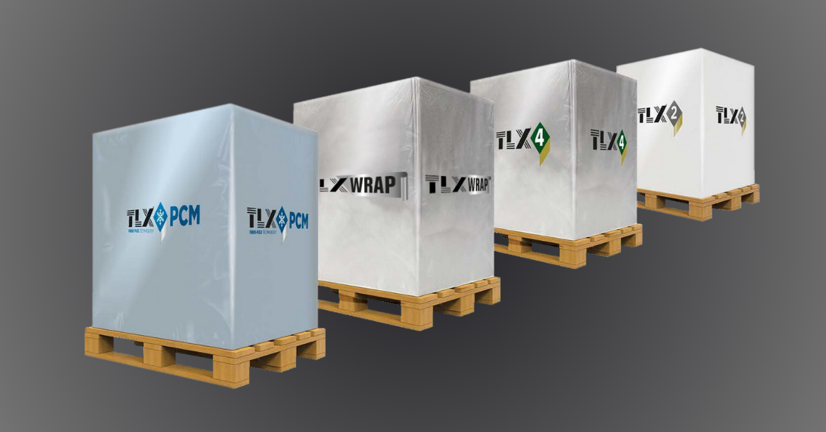 Four large, cube-shaped packages wrapped in branded silver and white coverings are stacked on wooden pallets, aligned in a diagonal row.