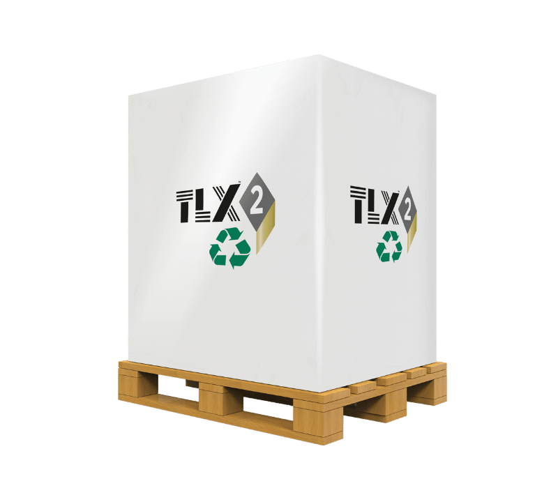 Large white box with "TLX2" and a green recycling symbol, placed on a wooden pallet. The background is black, highlighting the packaging.