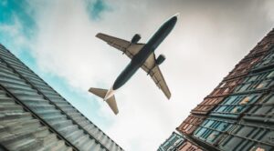 Air freight in pharma logistics: cargo plane flying over refrigerated containers transporting temperature-sensitive goods